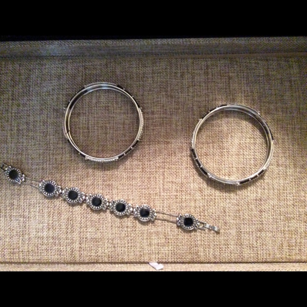 Three silver and black colored bracelets